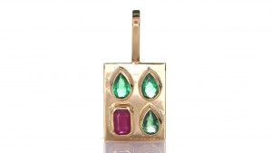 A Ruby With Three Green Sapphires Placed On A Gold Pendant