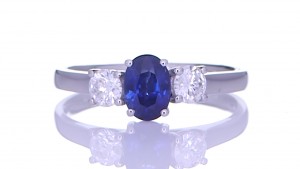 Blue Sapphire With Two Diamonds Placed On A Silver Ring