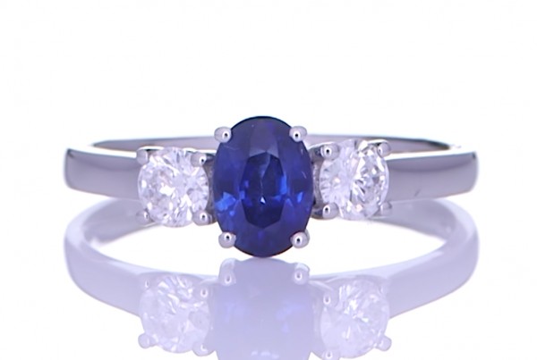 Blue Sapphire With Two Diamonds Placed On A Silver Ring