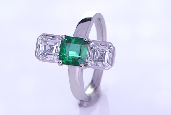 Green Sapphire And Two Diamonds Placed On A Silver Ring