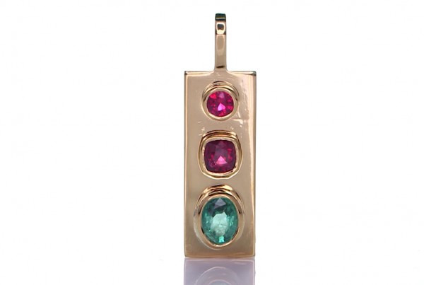 Green Sapphire And Two Rubies Placed On A Gold Pendant