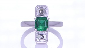 Green Sapphire With Two Diamonds Placed On A Silver Ring