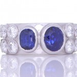 Two Blue Sapphires With Twelve White Diamonds Placed On A Silver Ring