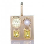 Two Golden Sapphires With A Yellow Emerald And A White Pearl Placed In A Golden Pendant