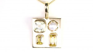 Two Golden Sapphires With A Yellow Emerald And A White Pearl Placed In A Golden Pendant