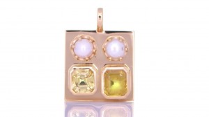 Two White Pearls With A Yellow and Golden Sapphire Placed On A Golden Pendant