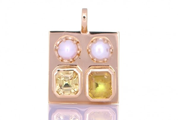Two White Pearls With A Yellow and Golden Sapphire Placed On A Golden Pendant