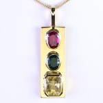 Golden Sapphire, Green Emerald And A Ruby On A Golden Pendant
