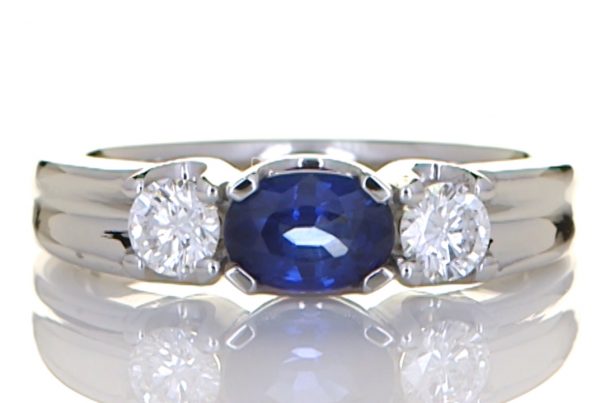 Two Diamonds With A Blue Sapphire Mounted Onto A Platinum Ring
